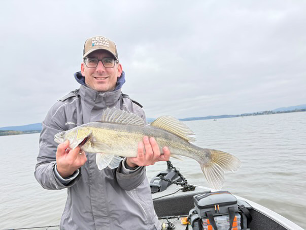 Stahlstadt-Angler mit einem gefangenen Zander auf dem Boot